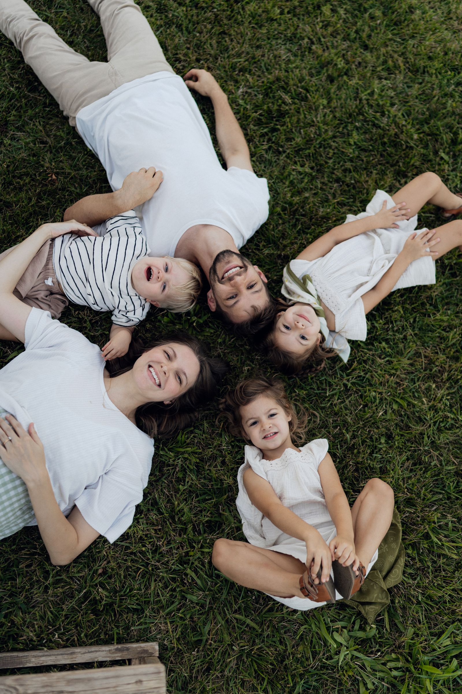Family of five relaxing on the grass on a sunny day